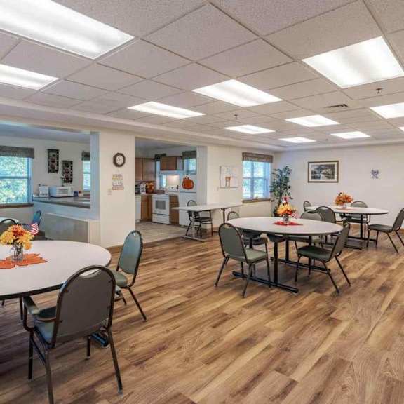 a room with tables and chairs and a flag on the wall.
