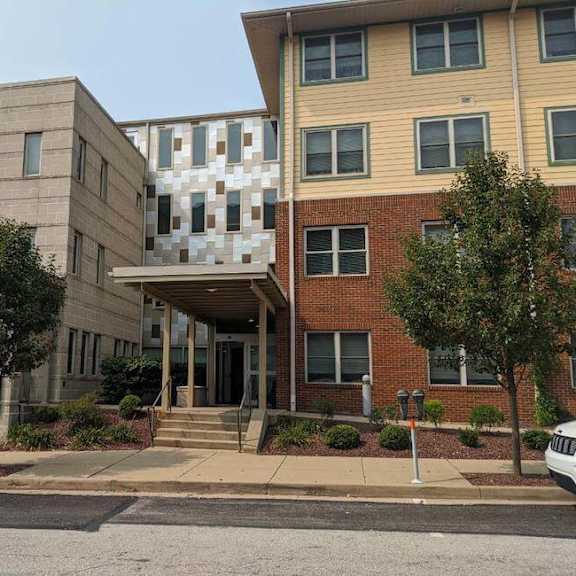 a building with a sign that says "hospital campus" in front of it.