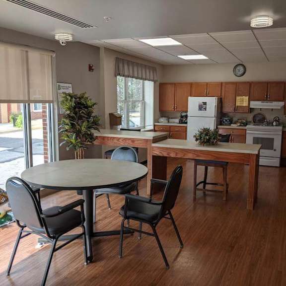 a kitchen with a table and chairs in front of a window.