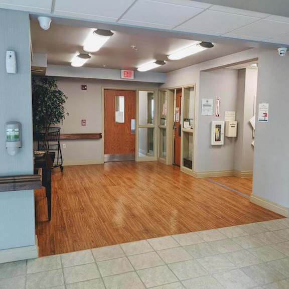 a hallway with a wooden floor and white walls.