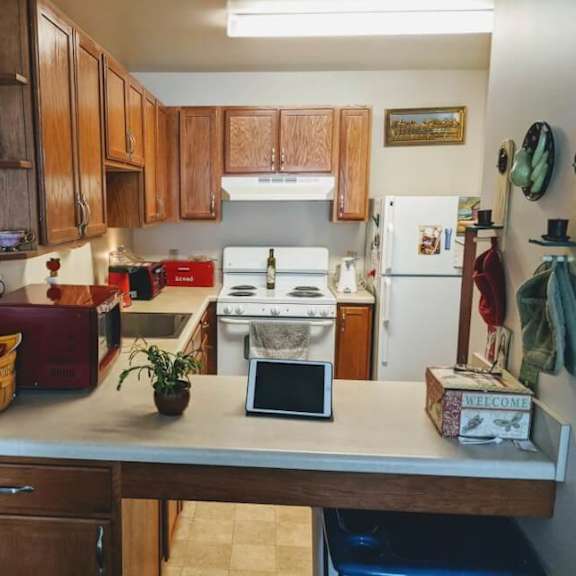 a kitchen with wooden cabinets and a white fridge.