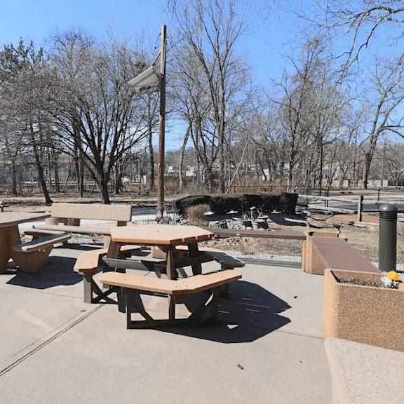 picnic tables are set up in a concrete lot.