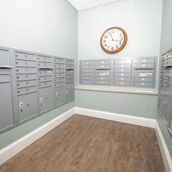 a room with a clock on the wall and mailboxes on the wall.