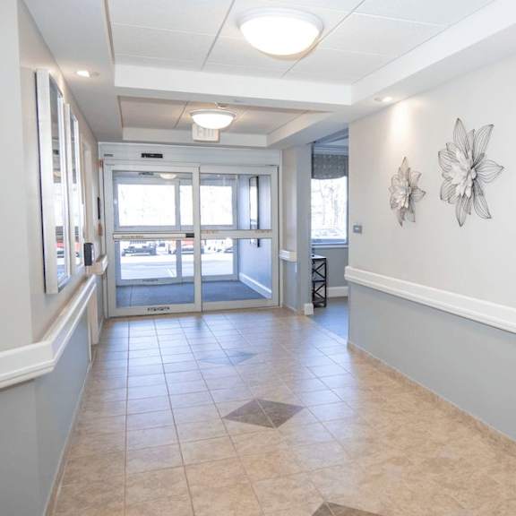 a hallway with a tiled floor and a row of flower decorations on the wall.