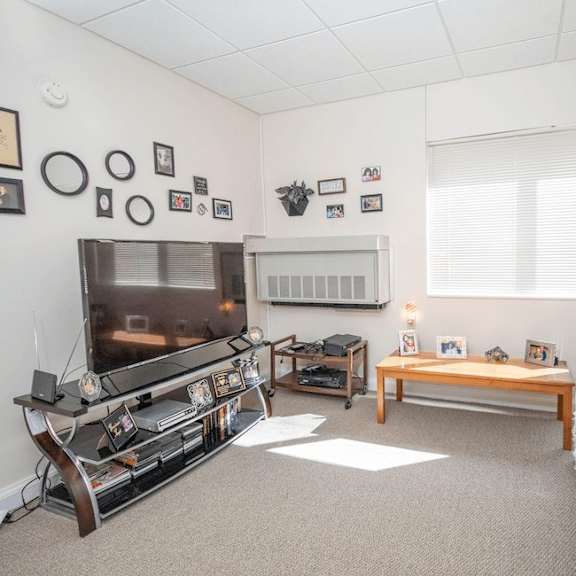 a living room with a flat screen tv, a couch, and a coffee table.