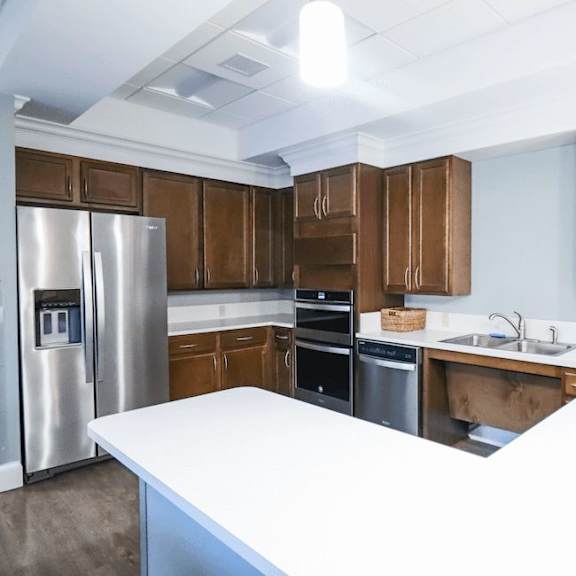 a kitchen with brown cabinets and a white counter.