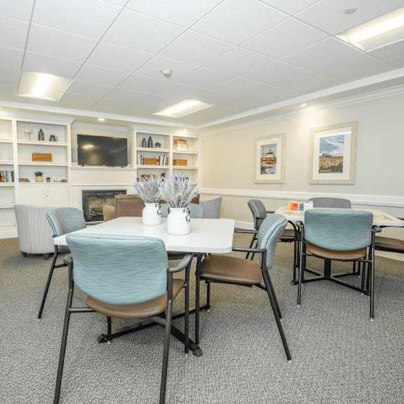 a conference room with a table, chairs, and a television.