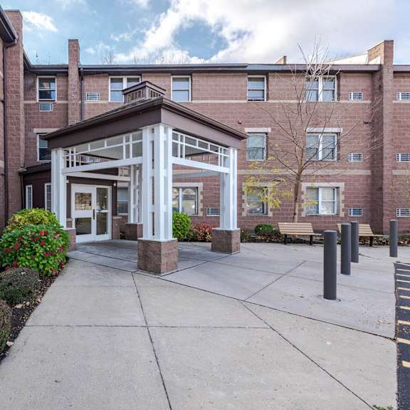 a brick building with a white entrance and a walkway in front.