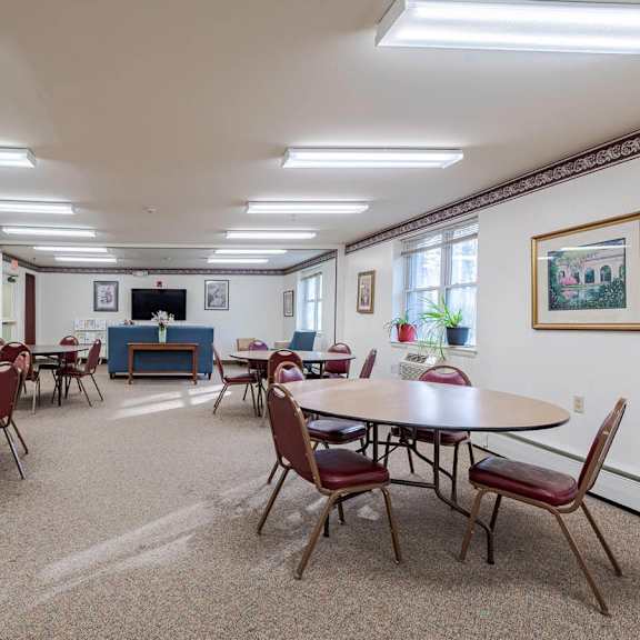 a room with tables and chairs and a piano.