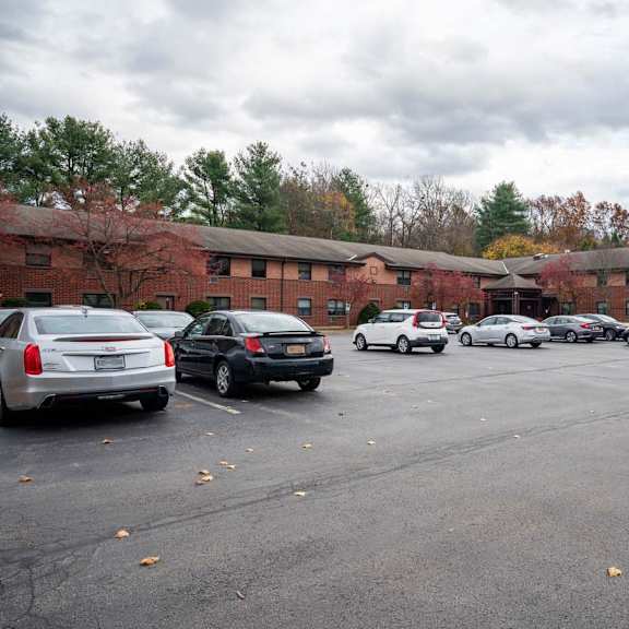 a parking lot with cars and a building in the background.