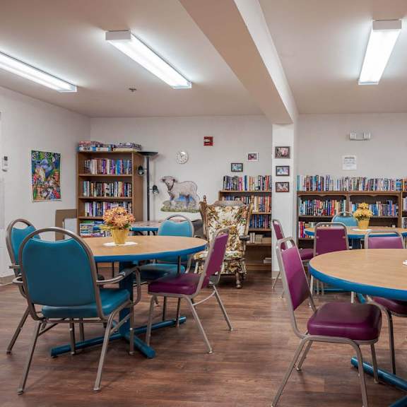 a library with tables, chairs, and bookshelves.