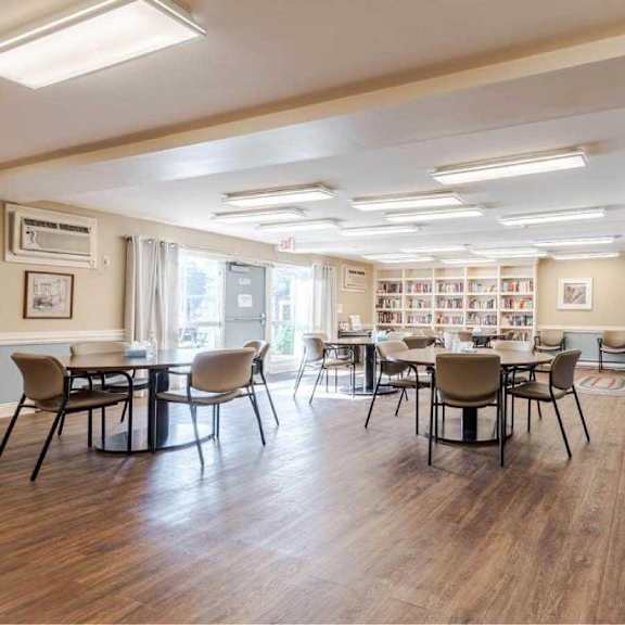 a room with a piano and chairs.