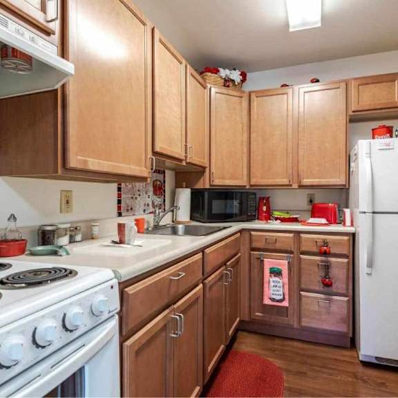 a kitchen with wooden cabinets and a white stove top oven.