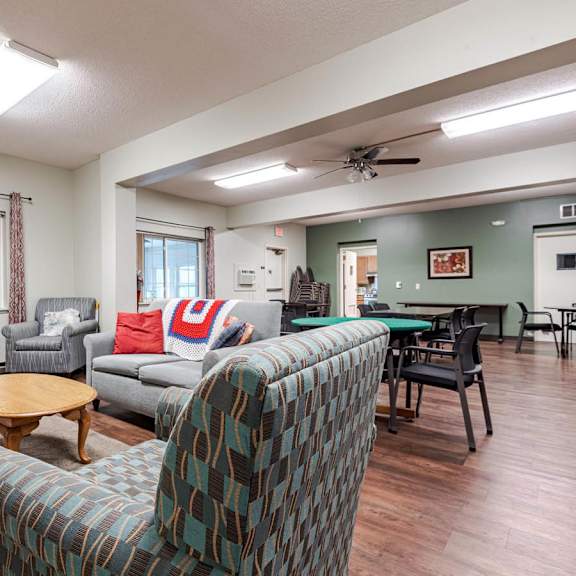 a living room with a couch, chairs, and a dining table.