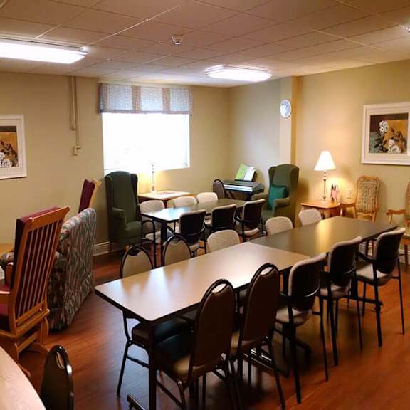 a room with a long table surrounded by chairs.