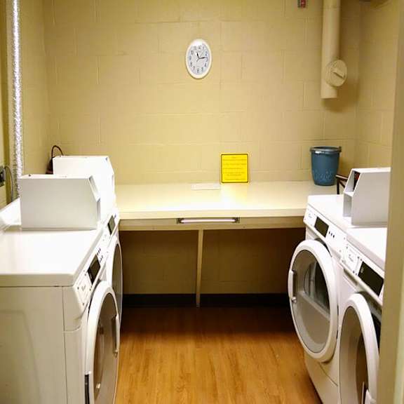 a laundry room with a washer and dryer on either side of a bench.