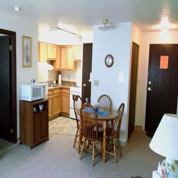 a kitchen area with a table and chairs.