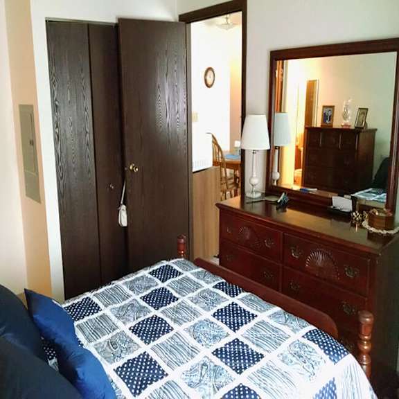 a bedroom with a bed, dresser, and mirror.