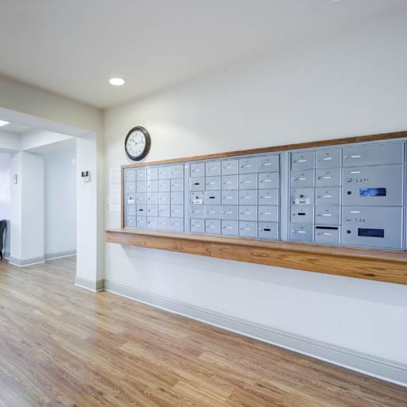 a room with a wooden floor and a long panel of switches on the wall.