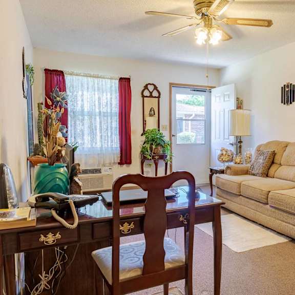 a living room with a tan couch and a wooden table.