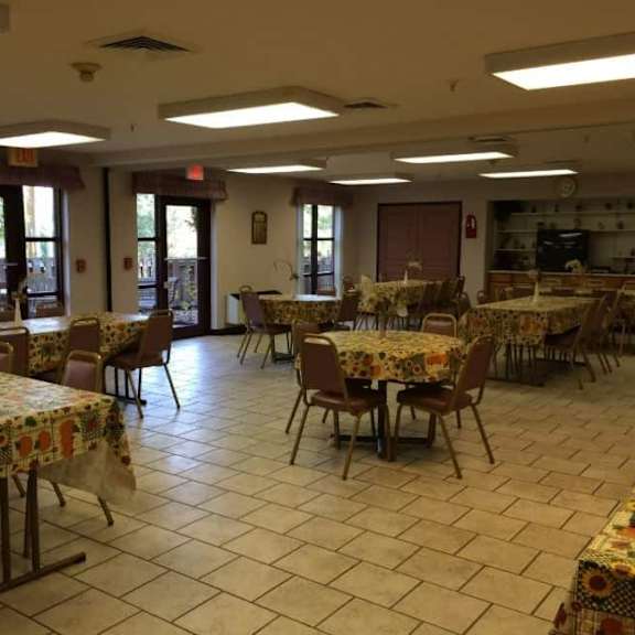 a room with tables and chairs set up for a gathering.