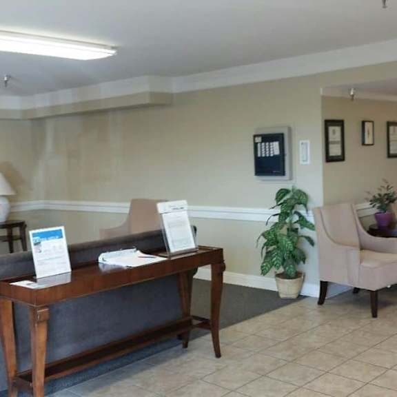 a reception area with a couch, chair, and a coffee table.