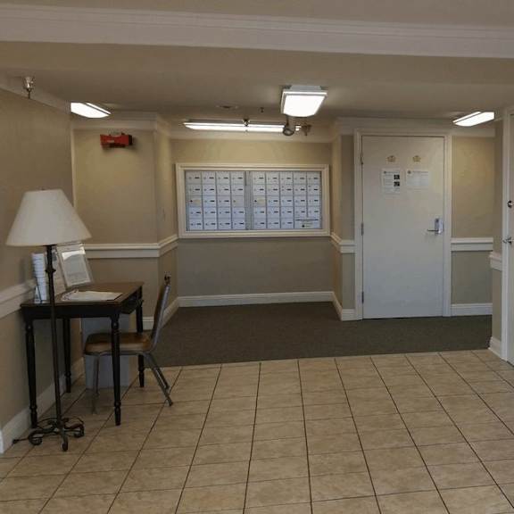 a room with a desk, chair, and a calendar on the wall.
