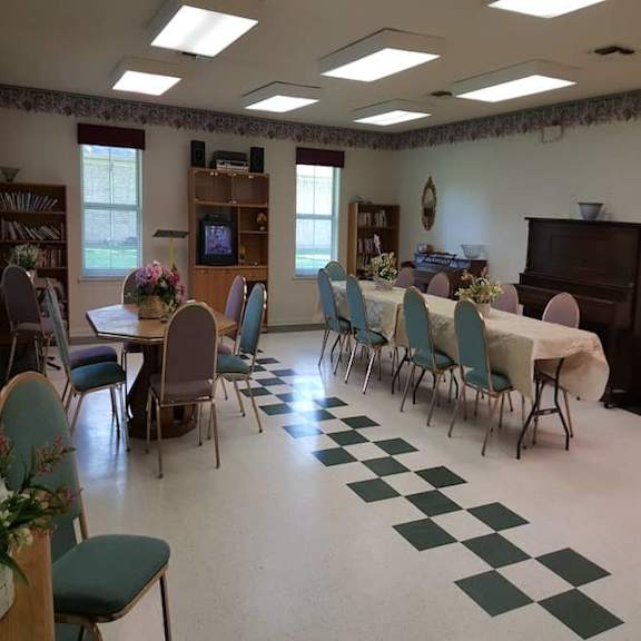 a room with a checkered floor and a long table with chairs.
