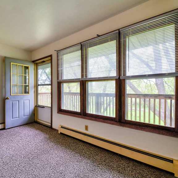 a room with a blue door and a window with blinds.