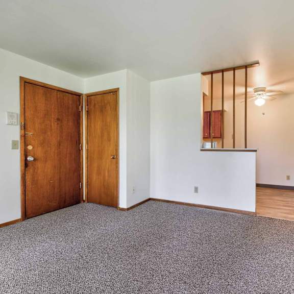 a room with a carpeted floor and a wooden door.