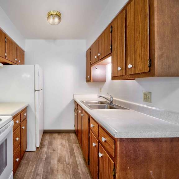 a kitchen with white appliances and wooden cabinets.