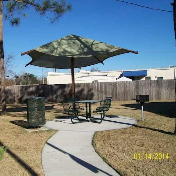 a patio with a table and chairs under an umbrella.