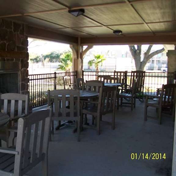 a patio with a table and chairs and a fireplace.