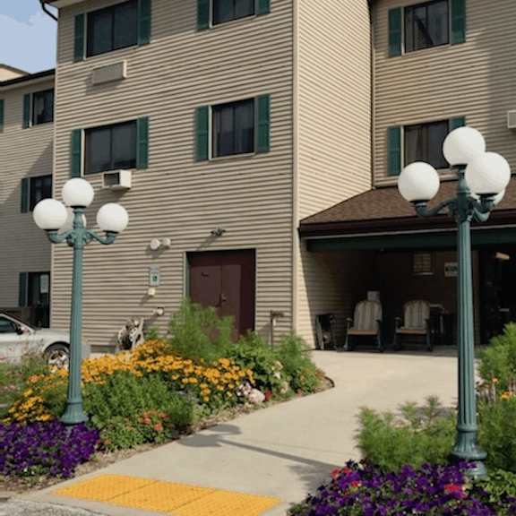 a building with a brown roof and a green lamp post in front of it.