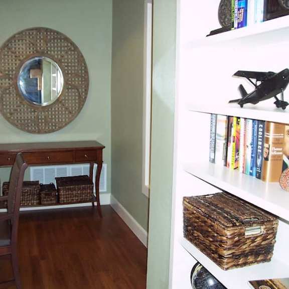 a room with a desk and a mirror on the wall.