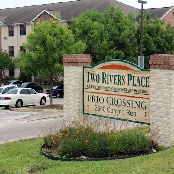 a sign for two rivers place in front of a building.