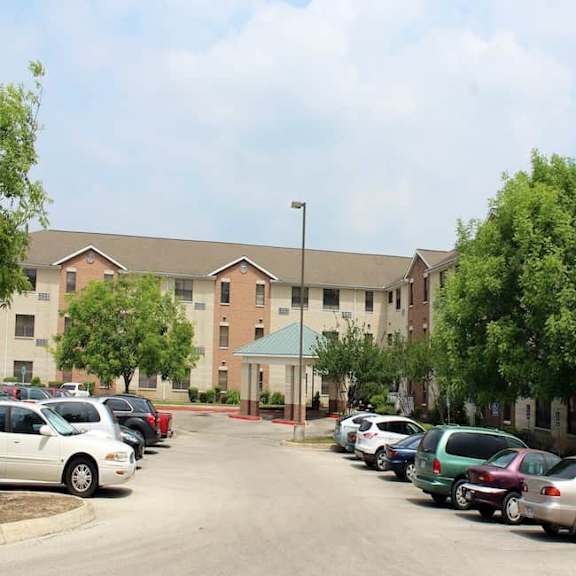 a parking lot with cars and a building in the background.