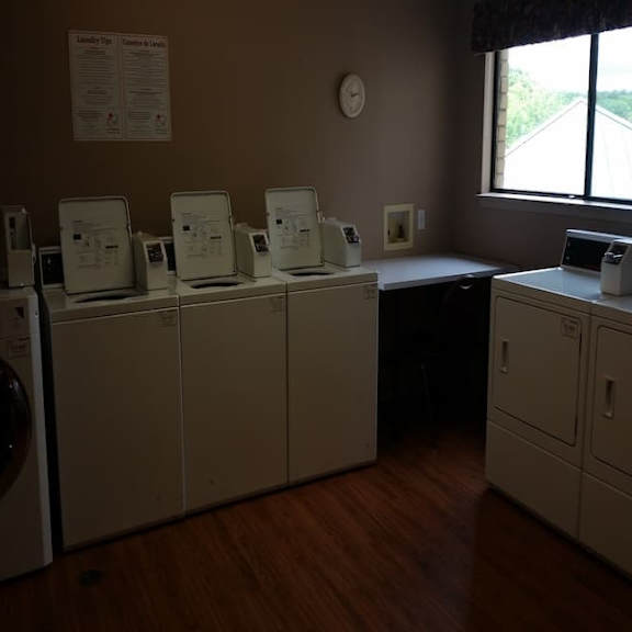 a laundromat with washers and dryers lined up.