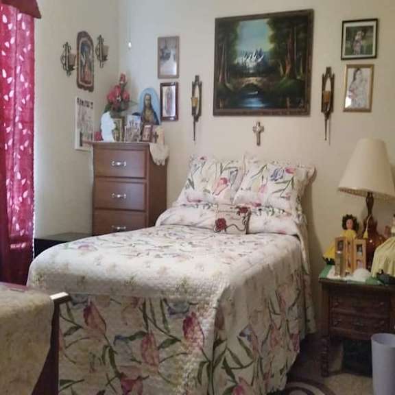 a bedroom with a bed, nightstand, and a painting on the wall.