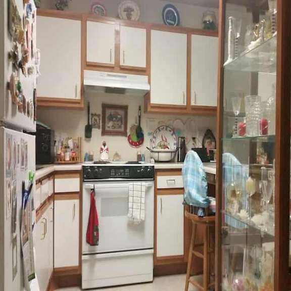 a kitchen with white appliances and wooden cabinets.