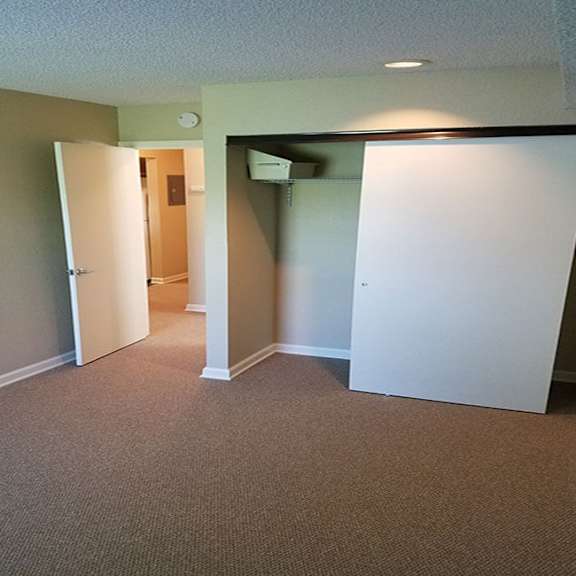 a room with carpeted floor and two white doors.