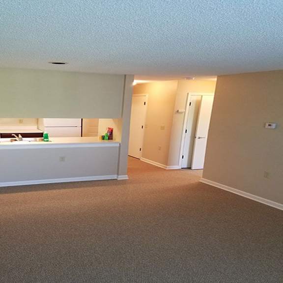 a room with a carpeted floor and a white countertop.