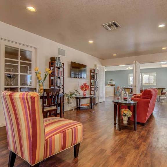 a living room with a red chair and a striped couch.