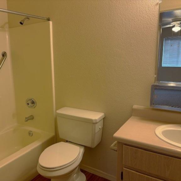 a white toilet sits next to a white sink in a small bathroom.