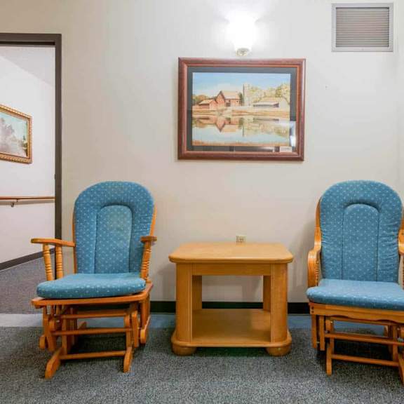 two blue chairs and a small table are in a room.
