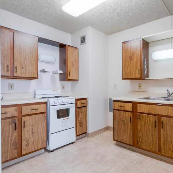 a kitchen with wooden cabinets and a white stove.