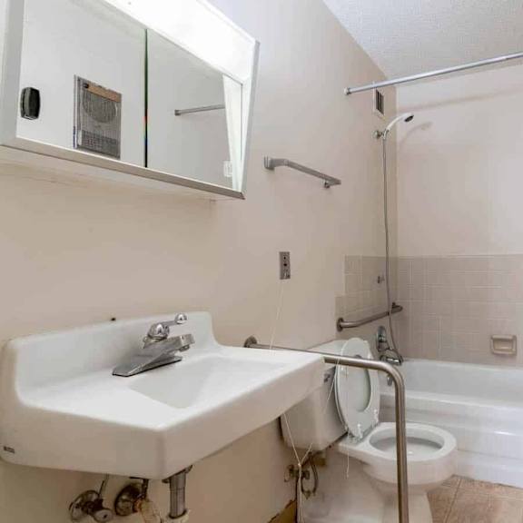 a white bathroom with a sink, toilet, and bathtub.