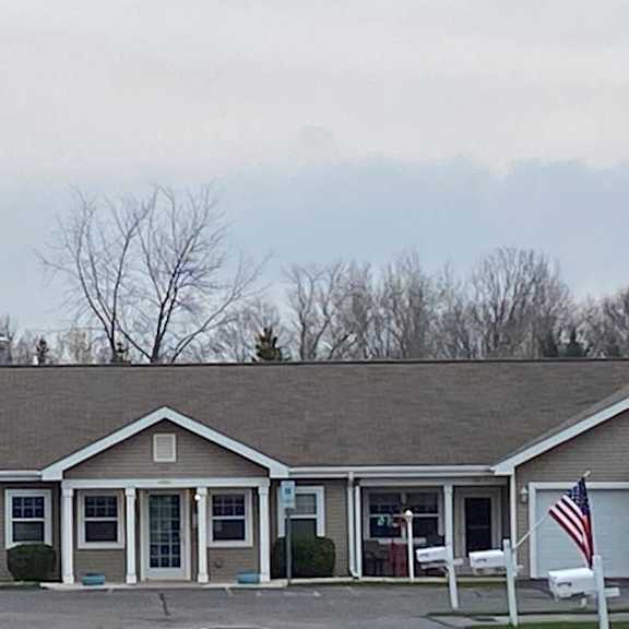 a building with a grey roof and a flag on the right side.
