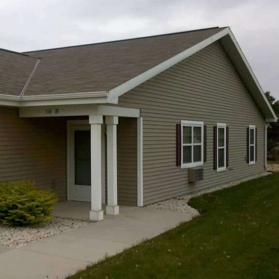 a house with a grey siding and a white door.