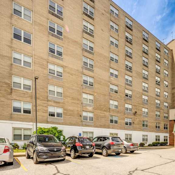 a parking lot in front of a large apartment building.